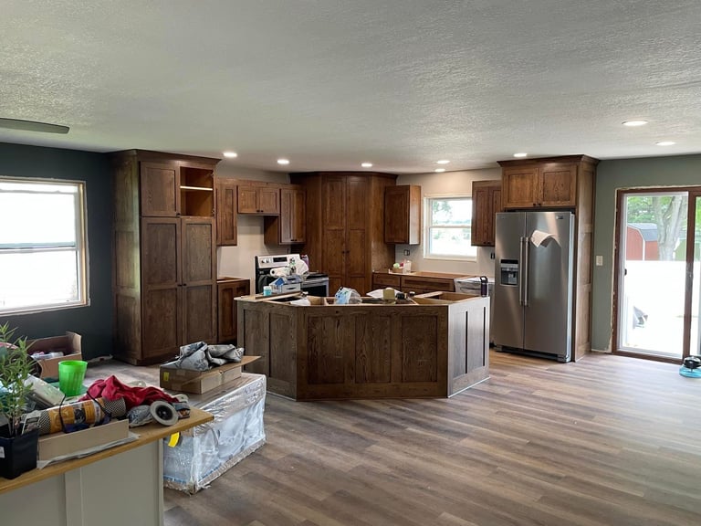 After: Modern kitchen with dark wood cabinets, stainless steel appliances, island countertop, and wood flooring in open floor plan home